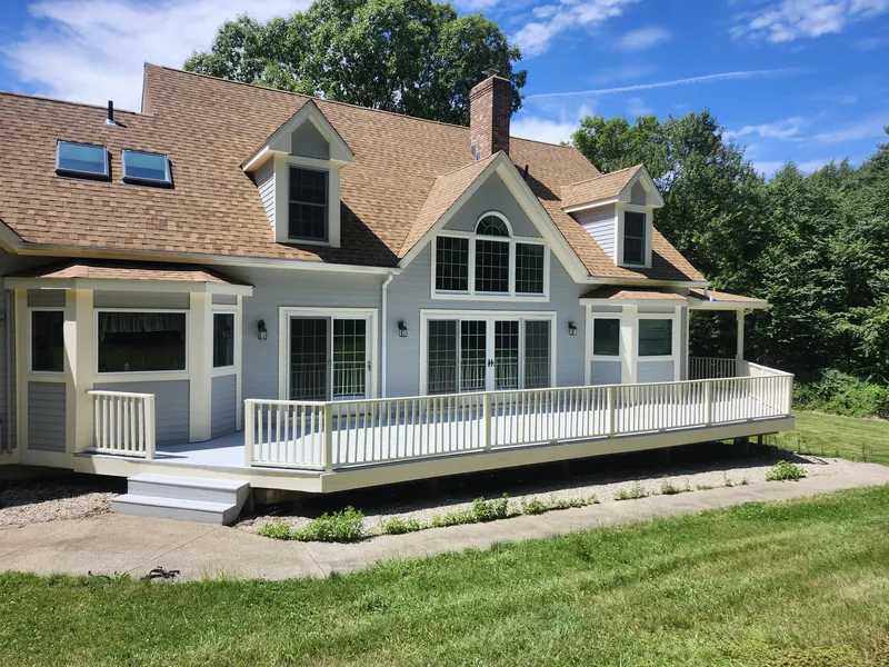 Wraparound deck on a cape with dormers